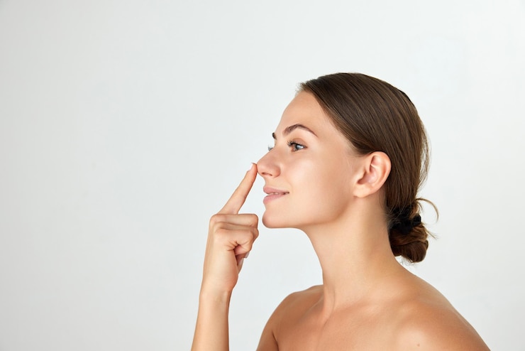 Photo side view of young attractive woman holding nose isolated on white background rhinoplasty surgery