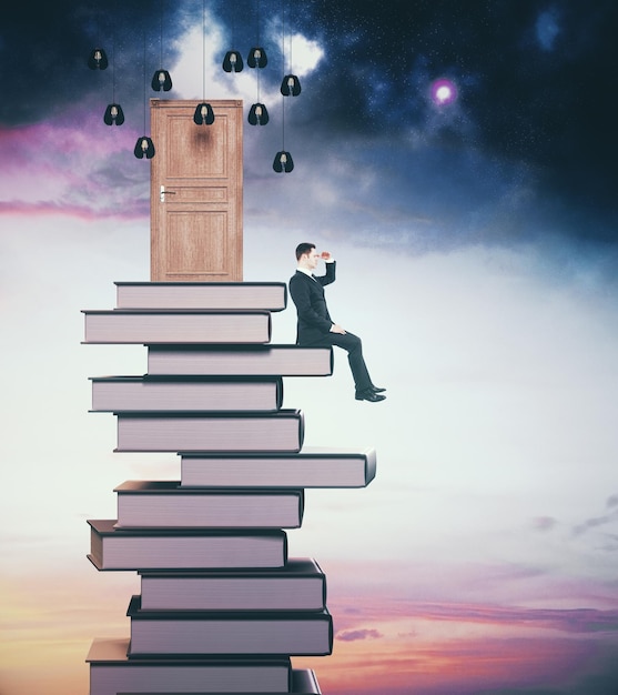 side view of young businessman sitting on book pile with abstract door and looking into the distance on sky background abstraction concept 3d rendering