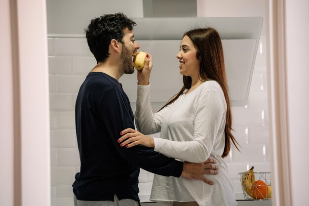 Side view of young couple standing against wall