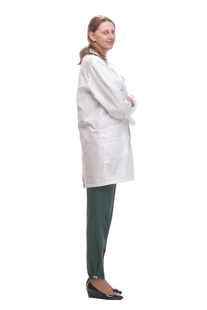 Side view of young female doctor or nurse standing over white background thoughtfully.