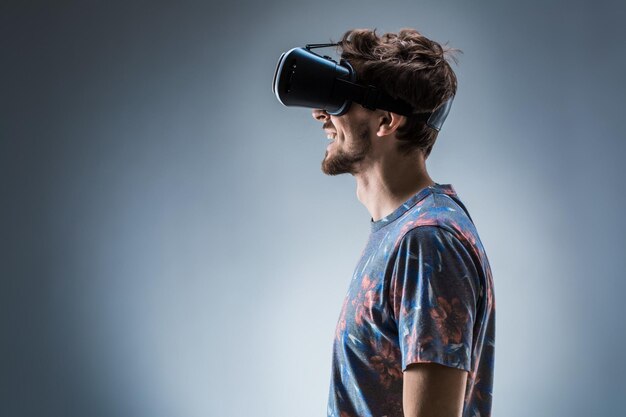 Side view of a young guy using a vr headset emotions