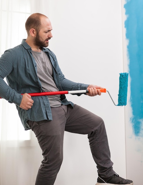 Side view of young man looking away against wall