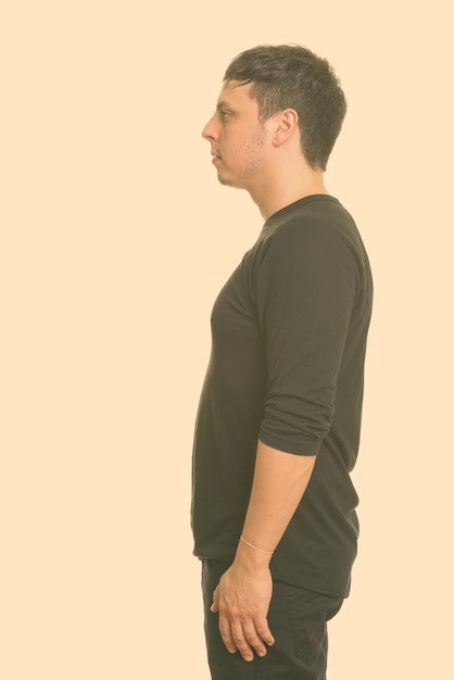 Photo side view of young man looking away against white background