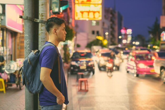 夜街を眺めている若者の横の景色