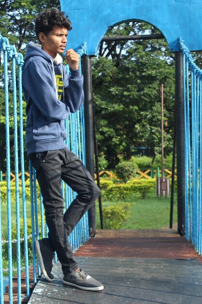 Side view of young man looking through railing