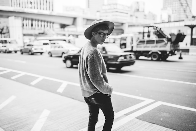 side view of young man wearing hat while standing on city street