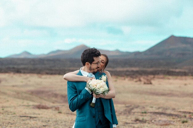 火山の景色に立っている若い男と女の横の景色