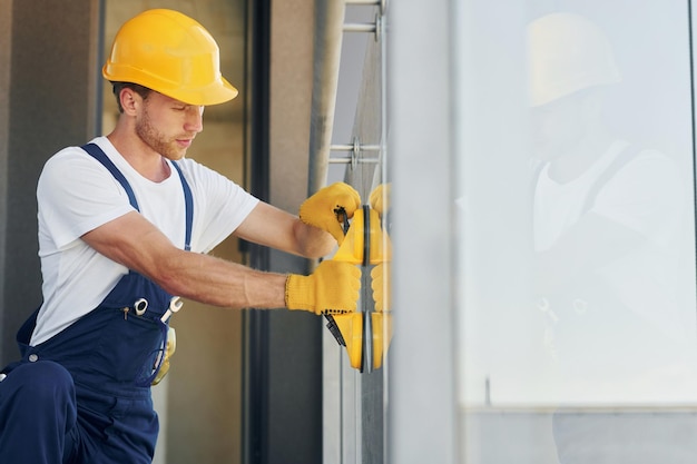 Side view Young man working in uniform at construction at daytime