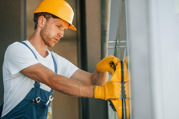 Side view Young man working in uniform at construction at daytime