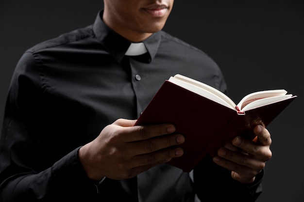 Side view young priest reading bible