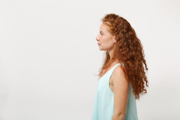 Side view of young smiling redhead woman girl in casual light clothes posing isolated on white background studio portrait. People sincere emotions lifestyle concept. Mock up copy space. Looking aside.