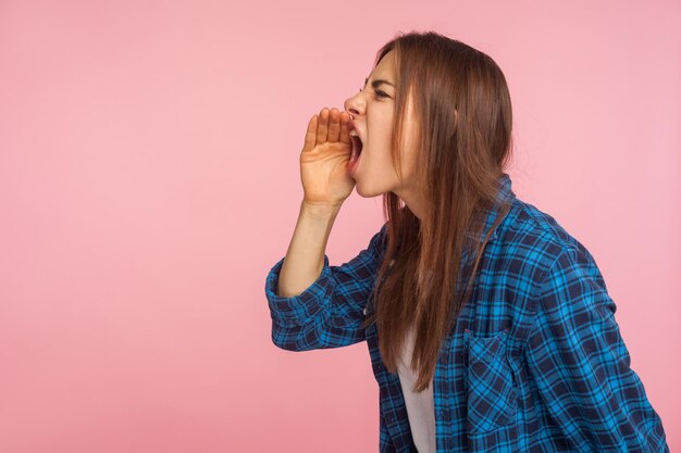 Foto vista laterale di una giovane donna sullo sfondo grigio