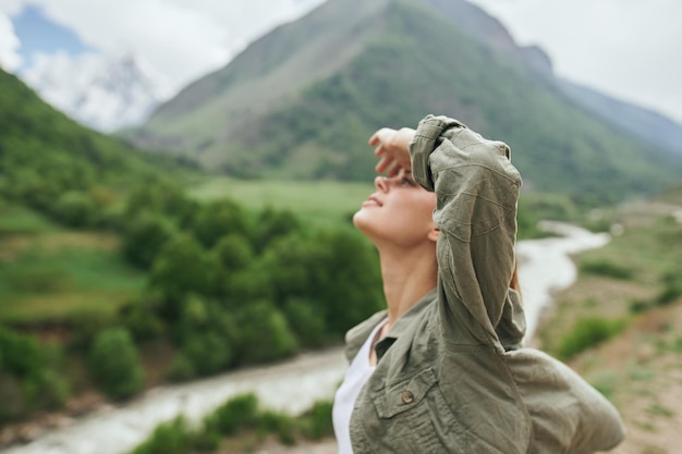 Photo side view of young woman against mountain range