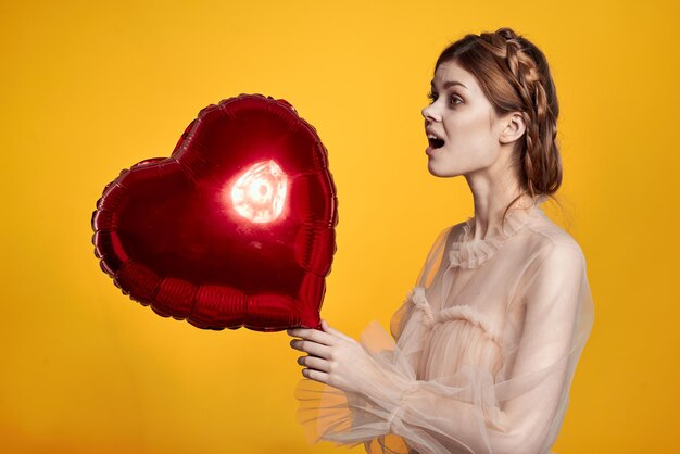 Side view of a young woman against yellow background