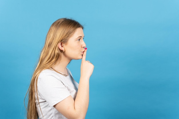 Side view of young woman asking for silence