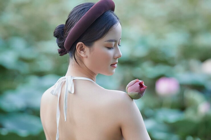 Photo 拿着花的年轻女子的侧面视图
