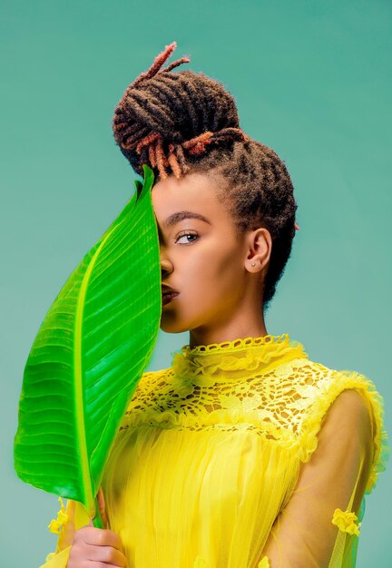 Side view of young woman holding plant