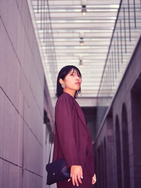 建物の向こうを見回す若い女性のサイドビュー
