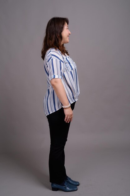 Photo side view of young woman looking away against white background