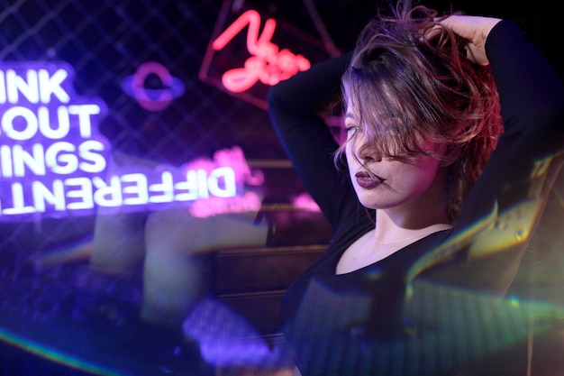 Photo side view of young woman looking through window