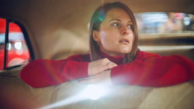 Photo side view of young woman looking through window