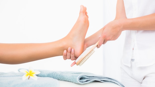 Side view of a young woman receiving pedicure treatment