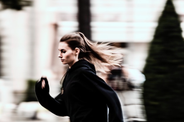 Foto vista laterale di una giovane donna che corre per strada