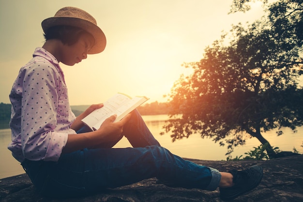 Side view of young woman sitting on book