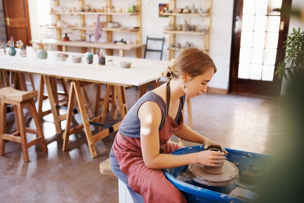 Photo side view of young woman sitting on chair at home