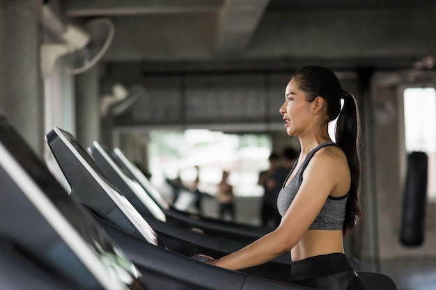 Photo side view of young woman sitting in gym