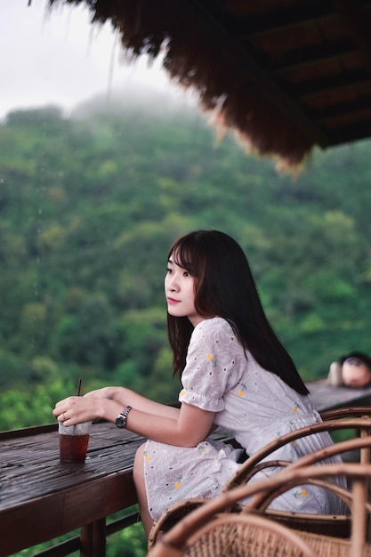 Side view of a young woman sitting outdoors
