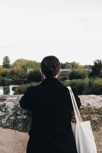 Photo side view of young woman standing against sky