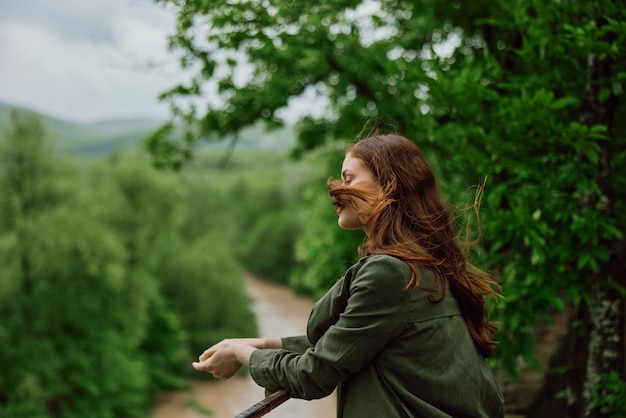 Photo side view of young woman standing against trees