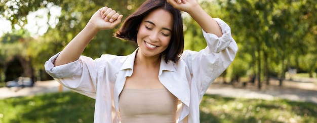 Side view of young woman standing against trees