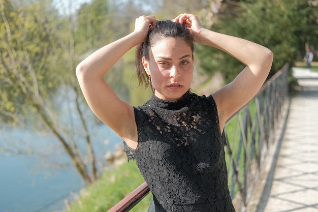 Photo side view of young woman standing against trees