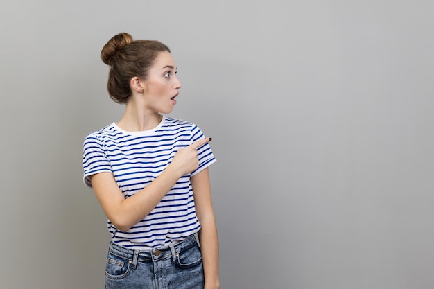 Photo side view of young woman standing against wall