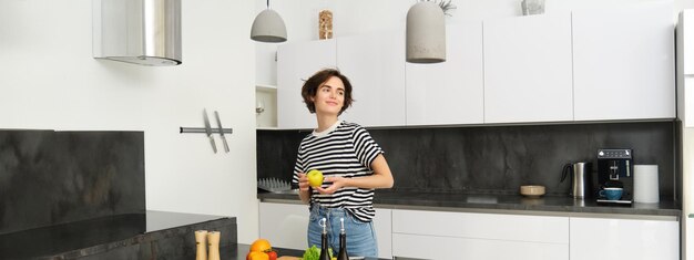 Photo side view of young woman standing against wall