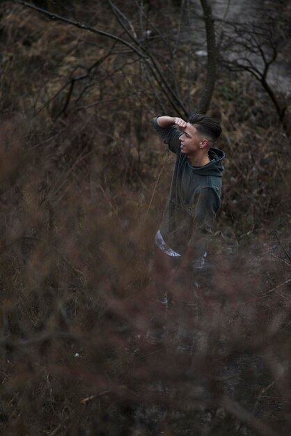 Foto vista laterale di una giovane donna in piedi su un albero nudo