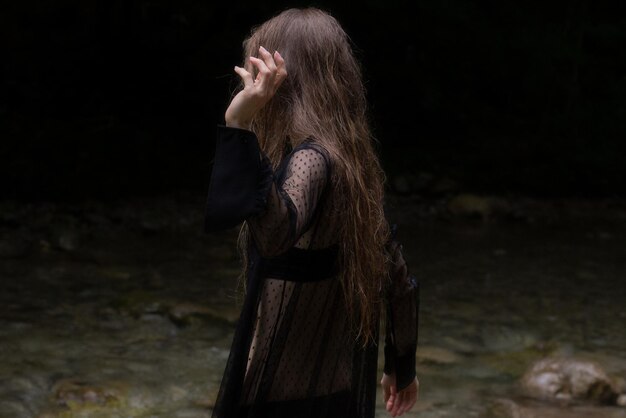 Photo side view of young woman standing outdoors