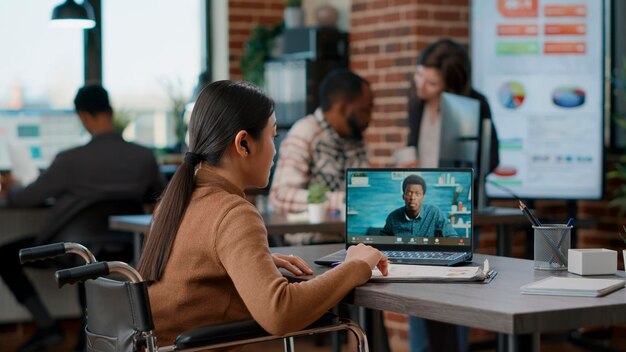 Photo side view of young woman using laptop while sitting in cafe