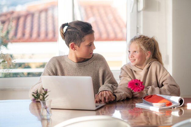 Photo side view of young woman using laptop while sitting on table