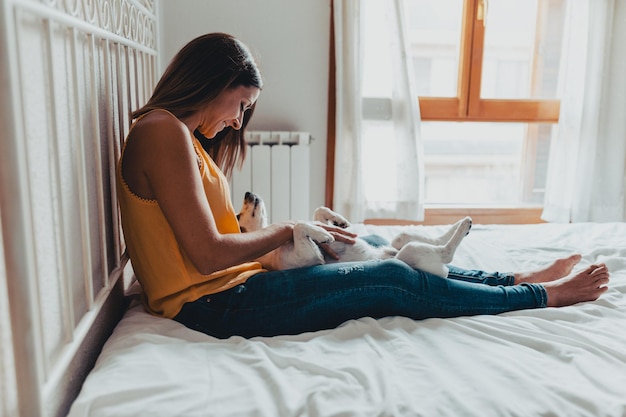 家で携帯電話を使っている若い女性のサイドビュー
