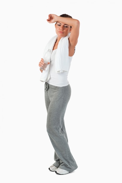 Side view of young woman wiping off sweat from her forehead