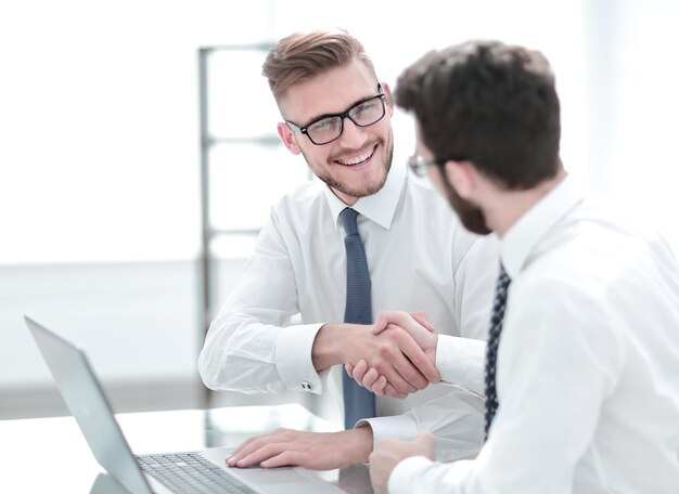 Side viewsmiling employees shaking hands