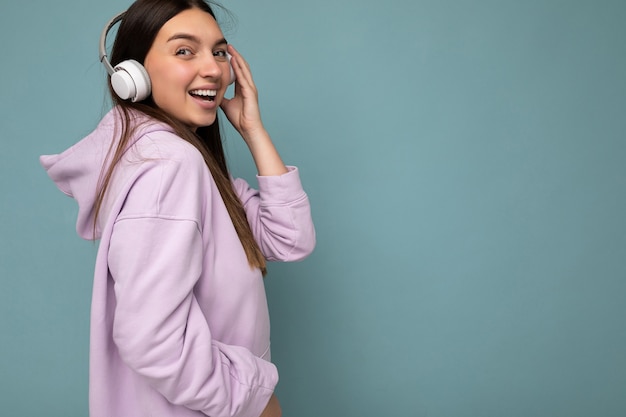 Sideprofile beautiful happy smiling young brunette woman wearing light purple hoodie