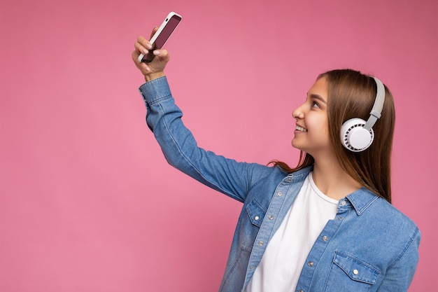 Sideprofile photo of beautiful positive smiling young dark blonde woman wearing blue jean stylish