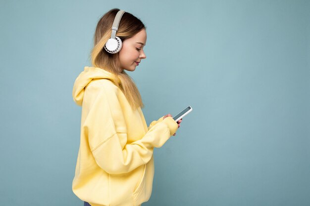 Sideptofile-foto van mooie jonge vrouw die een stijlvolle, casual outfit draagt, geïsoleerd over kleurrijk