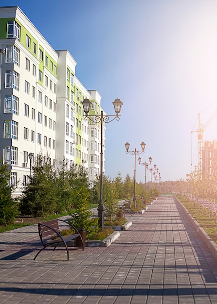 sidewalk near a multistorey building in the rays of the sun