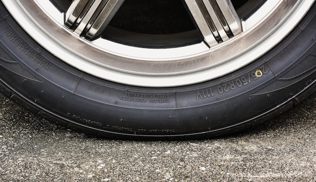 Photo sidewall of the  car tire with a low tire pressure on the road,close up