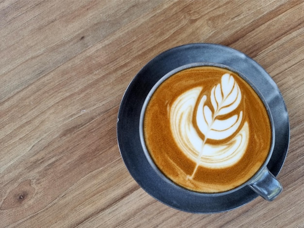 Sideway shop koffie een kopje hete latte art koffie op houten achtergrond